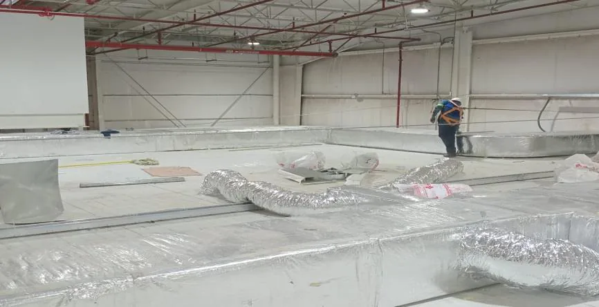 Nave con ductos rectangulares aislados en piso durante montaje por etapas