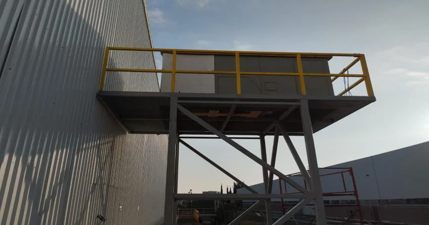 Plataforma estructural exterior con barandal amarillo que soporta equipo HVAC en fachada