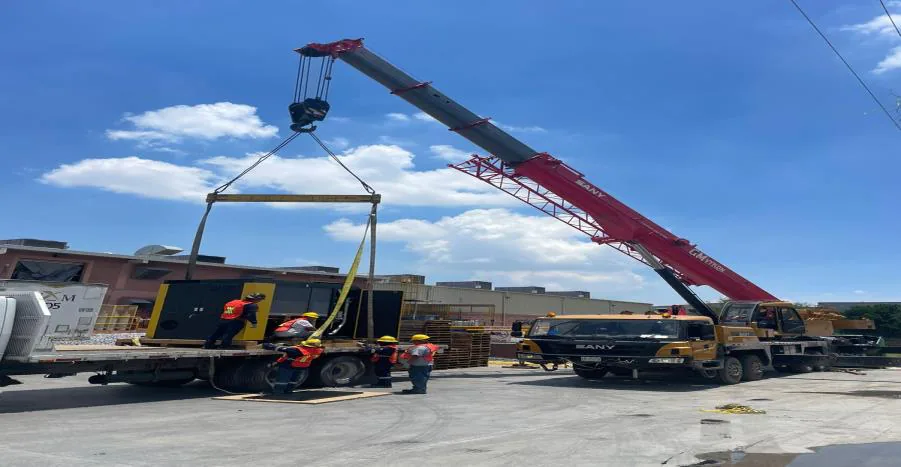 Grúa colocando una unidad HVAC sobre una plataforma junto al edificio de la planta Honeywell en San Luis Potosí